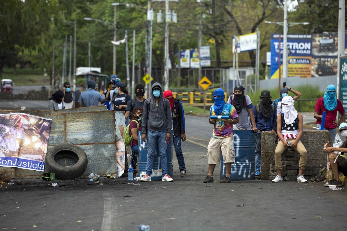 Manifestantes resguardan una barricada hecha de adoquines en los alrededores de la Universidad Nacional Autónoma de Nicaragua. (EFE).