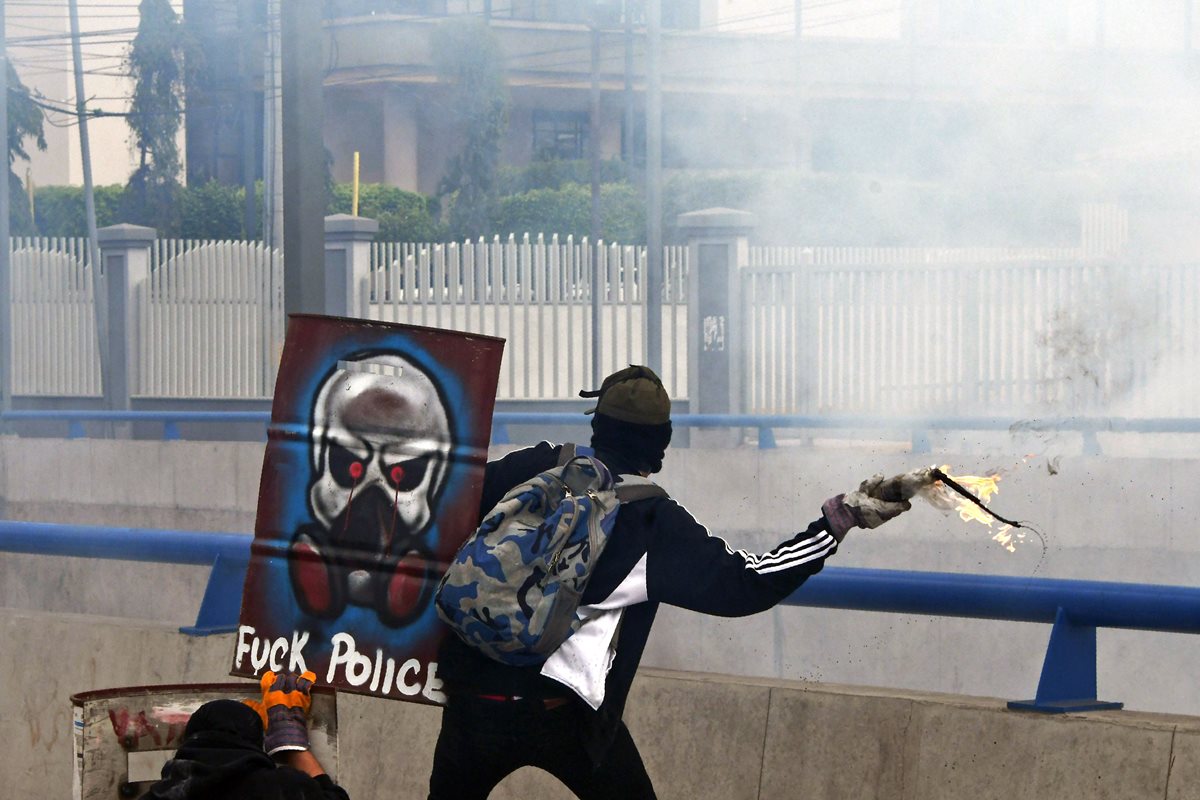 Un manifestante lanza una bomba molotov contra los policías. (Foto Prensa Libre: AFP)