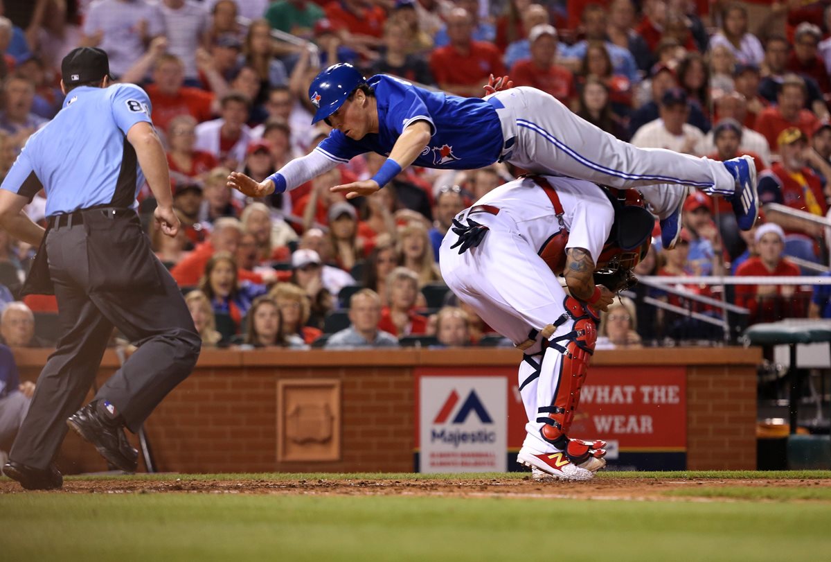 Chris Coghlan realizó un salto acrobático por encima del cátcher Yadier Molina. (Foto Prensa Libre: AFP)