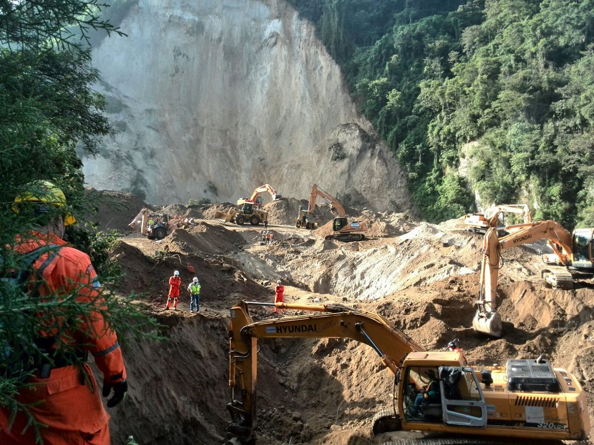 Maquinaria remueve escombros para llegar a las casas. (Foto Prensa Libre: Estuardo Paredes)