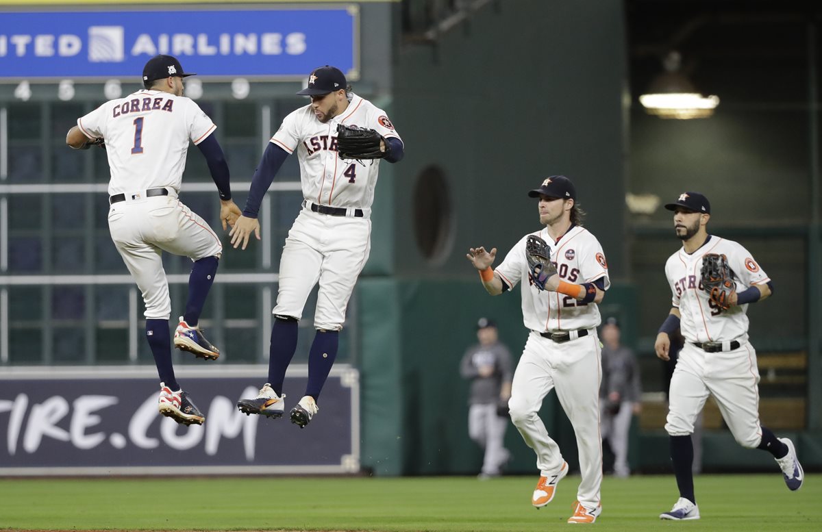 Carlos Correa y George Springer celebran al terminar el sexto juego frente a los Yanquis. (Foto Prensa Libre: AP)