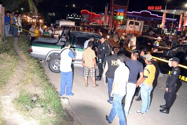 Fiscales del Ministerio Público y agentes de la Policía Nacional Civil inspeccion la escena del crimen en Puerto Barrios. (Foto Prensa Libre: Edwin Perdomo)