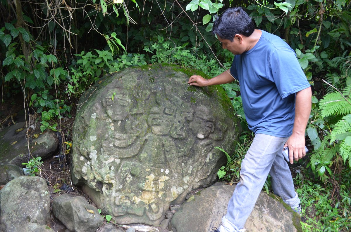 Arqueólogo muestra figuras de personajes talladas en una piedra por antepasados, la cual se halla en el sitio arqueológico de San Felipe, Retalhuleu. (Foto Prensa Libre: Jorge Tizol)