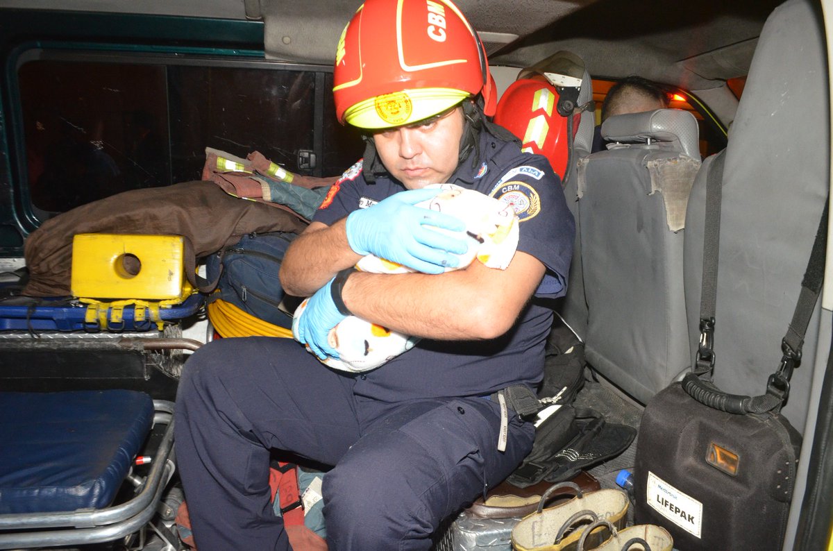 Socorristas examinan a una bebé que fue abandonada en la zona 1 de la capital. (Foto Prensa Libre: Bomberos Municipales)