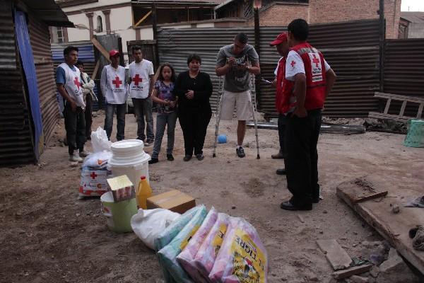 Miembros  de  la  Cruz Roja Guatemalteca entregan   ayuda  a la familia  Castillo Mérida  en su hogar  temporal, en San Pedro Sacatepéquez.