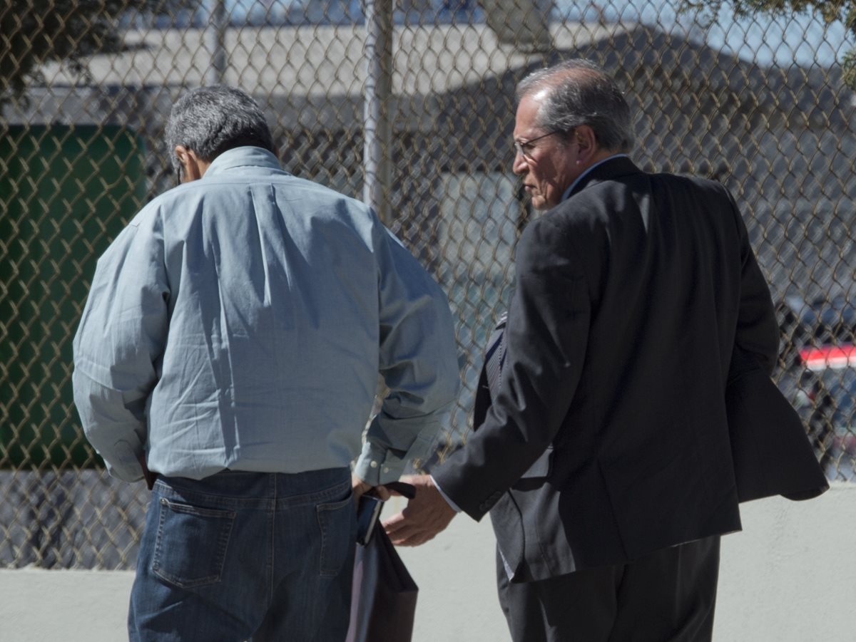 Los abogados José Luis González Meza (izquierda) y Juan Pablo Badillo (derecha), caminan en las afueras del penal del Altiplano. (Foto Prensa Libre: AFP).