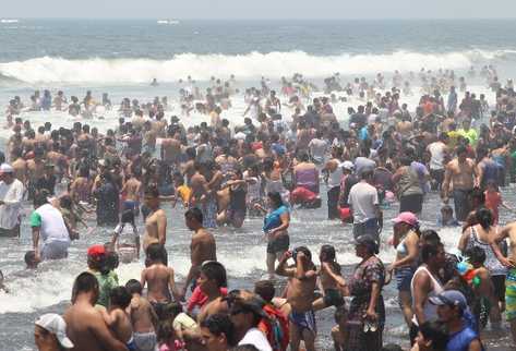 Los veraneantes, entre mujeres, hombres y niños llegados de diferentes lugares,   disfrutan  del mar en  Puerto San José, Escuintla.