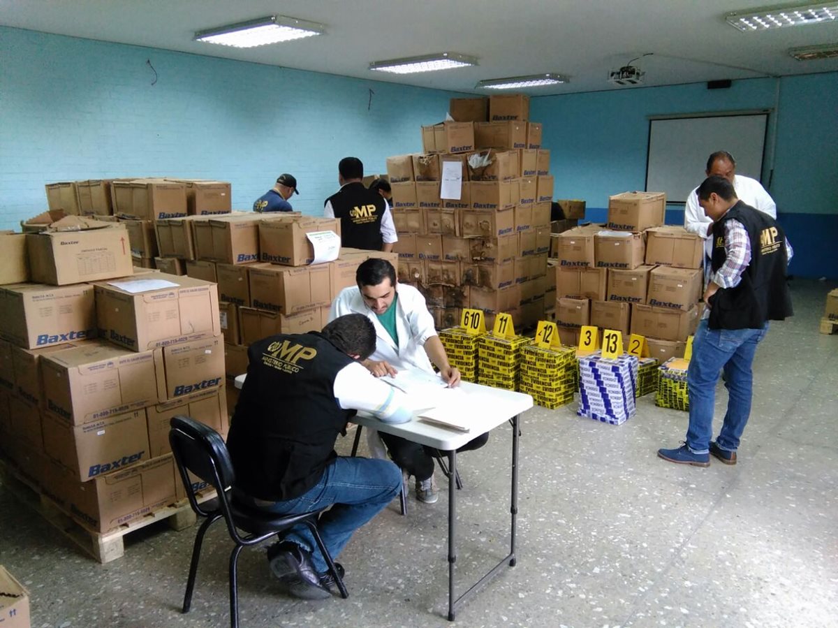 Fiscales del Ministerio Público embalan cajas que contienen solución salina, ubicadas en el Hospital Infantil de Infectología y Rehabilitación. (Foto Prensa Libre: Estuardo Paredes)