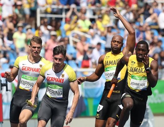 Nickel Ashmeade, derecha, releva a Asafa Powell, al lado de los alemanes Robert Hering y Sven Knipphals, en los relevos 4X100 de Río 2016(Foto Prensa Libre: AP)