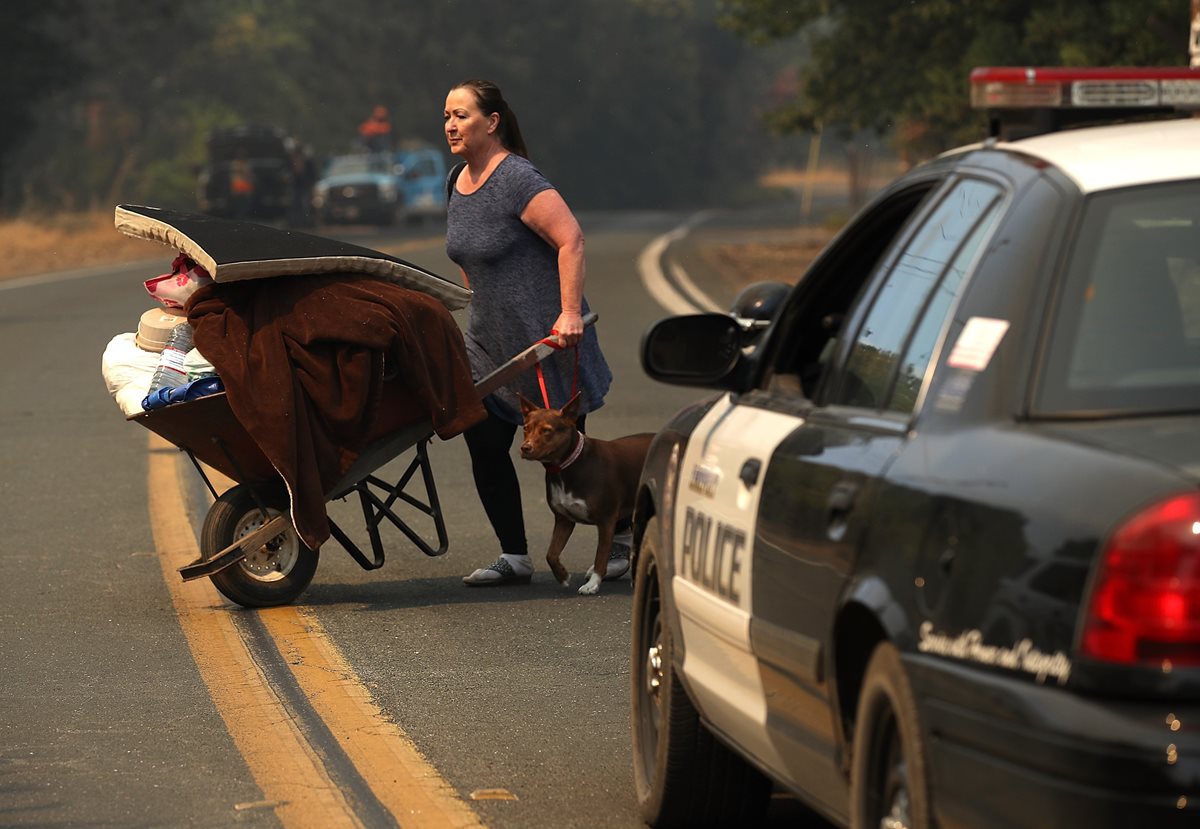 Una mujer abandona su vivienda mientras es evacuada en Lakeport, California. (AFP)