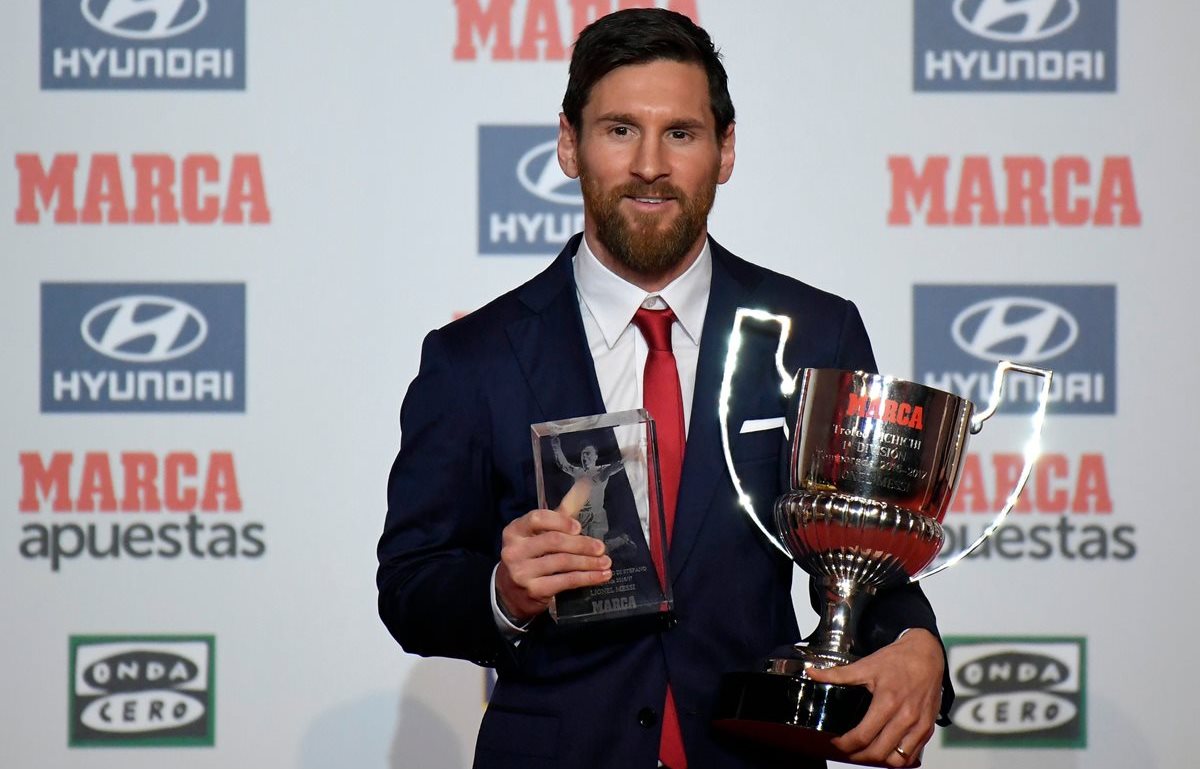 Lionel Messi posa con los trofeos de Alfredo Di Estefano y el trofeo de Pichichi. (Foto Prensa Libre: AFP)