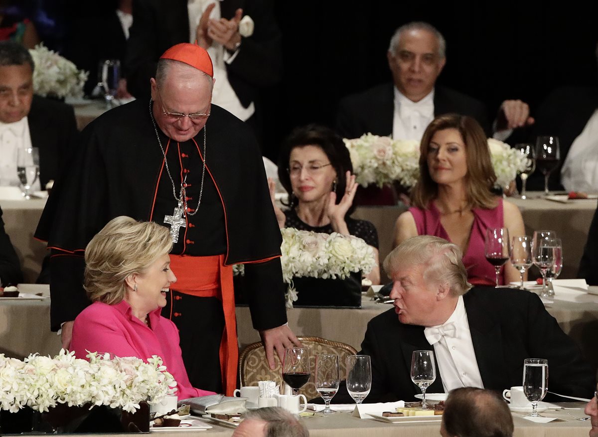 Hillary Clinton y Donald Trump cruzan palabras durante la cena benéfica que terminó con fuertes acusaciones, observa Timothy Cardinal Dolan, arzobispo de Nueva York. (Foto Prensa Libre: AP).