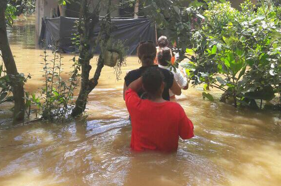 Personas caminan en medio del agua en una aldea de Los Amates, Izabal. (Foto Prensa Libre: Dony Stewart)