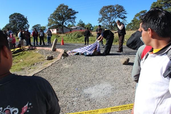 Un Agente del MP cubre el cadáver del alcalde comunitario, en San Pedro Jocopilas, Quiché.