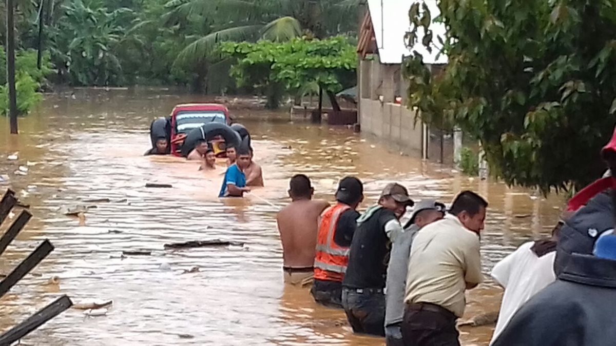 Un grupo de pobladores jalan un mototaxi que se encontraban en la calle principal del barrio Paz y Desarrollo. (Foto Prensa Libre: Eduardo Sam)