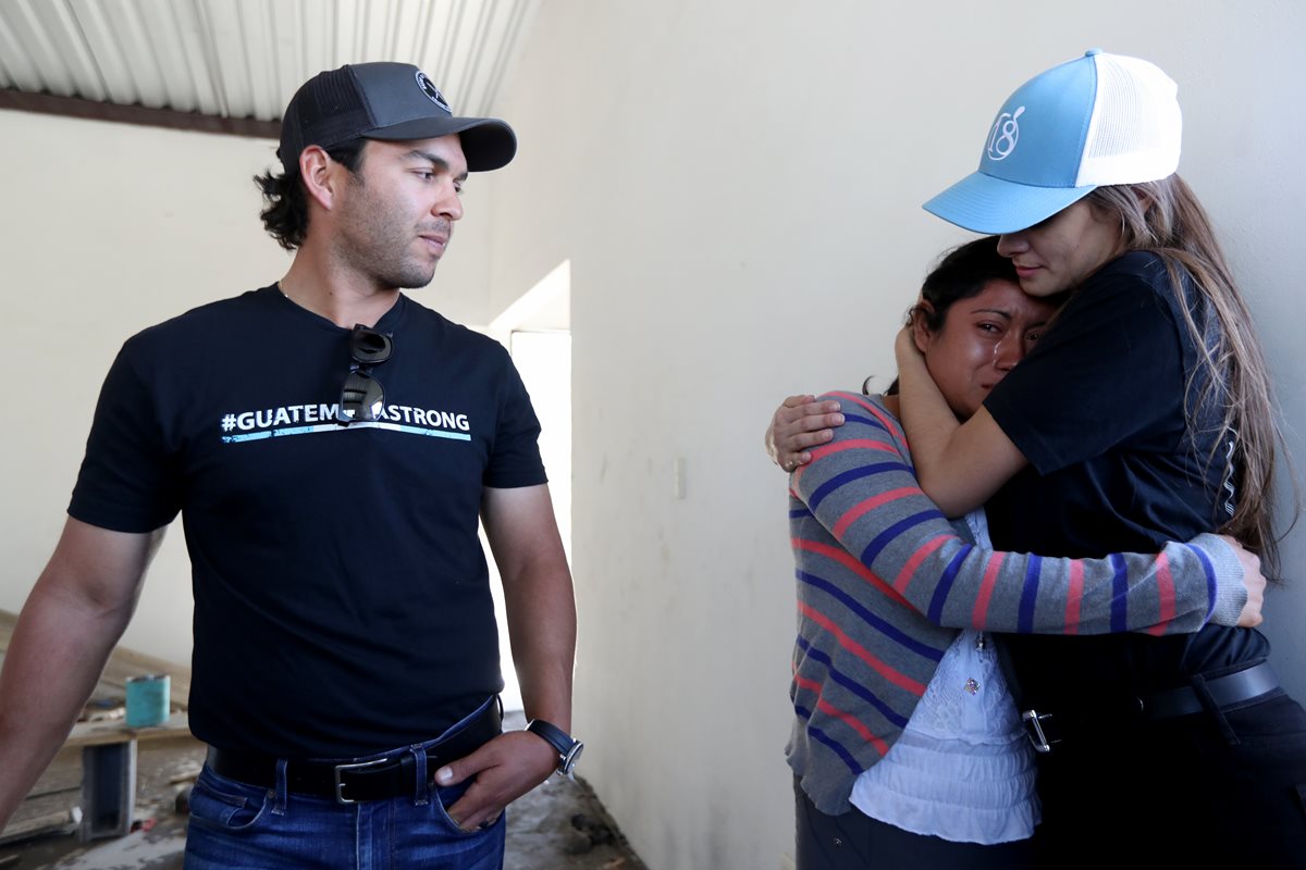 Laura de Toledo (derecha) consuela a Milda quien se acongoja cuando recuerda la tragedia del Volcán de Fuego. Observa el golfista José Toledo. (Foto Prensa Libre: Carlos Vicente)