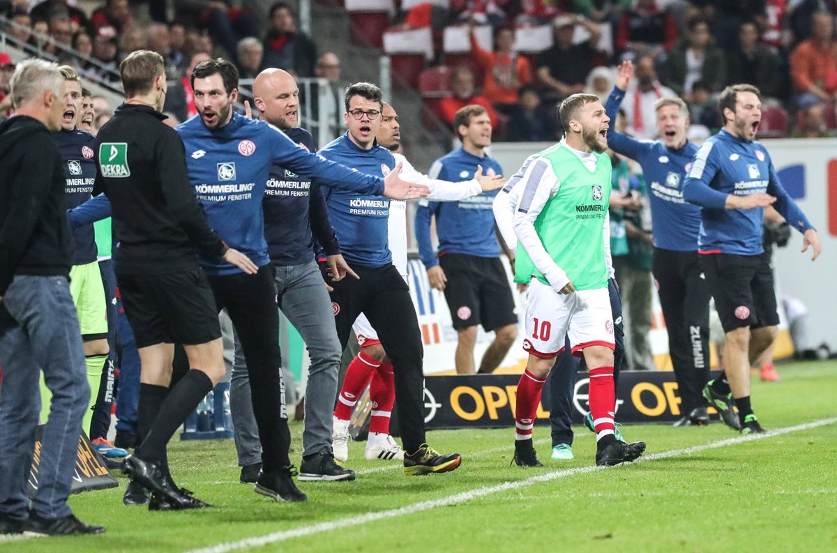 El entrenador del Maguncia Sandro Schwarz (3i) conversa con el cuarto árbitro para reclamarle un penalt al final del primer tiempo del partido de la Bundesliga alemana. (Foto Prensa Libre: EFE)