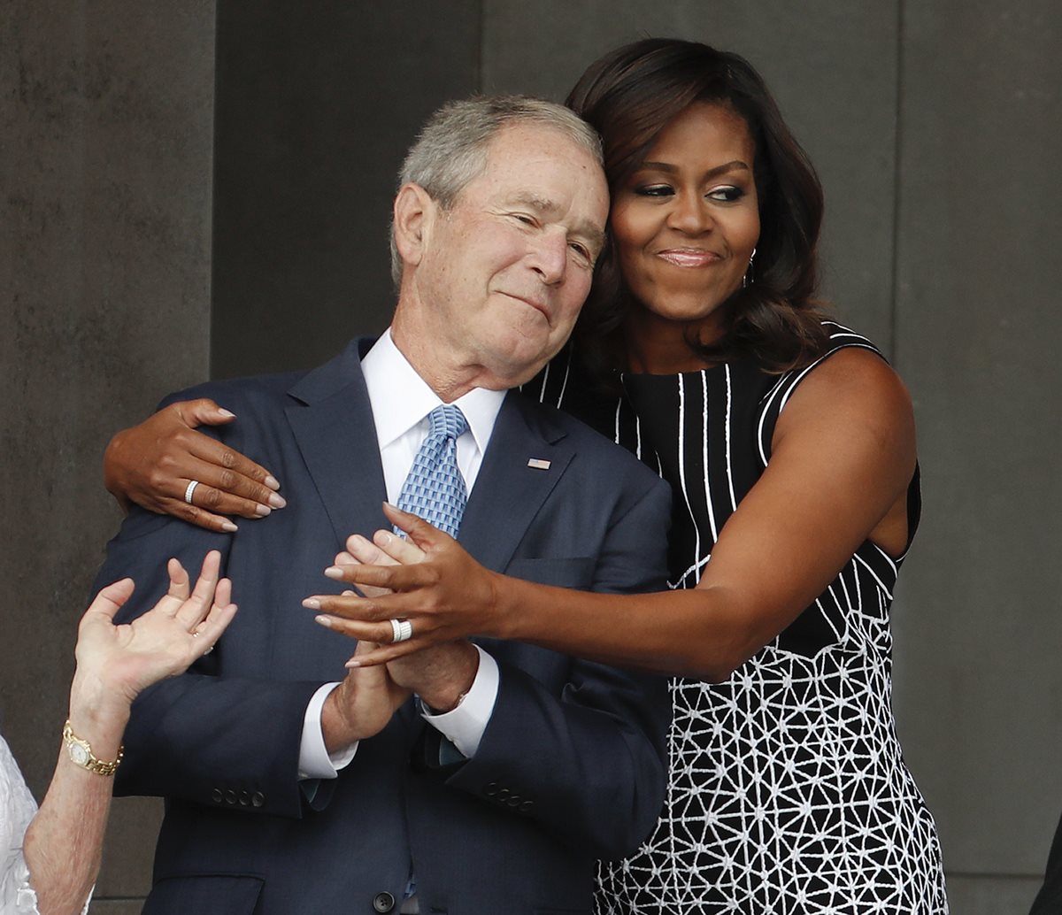 El expresidente de EE. UU., George W. Bush recibe el abrazo de la esposa del presidente Barack Obama, Michelle Obama. (Foto Prensa Libre: AP).