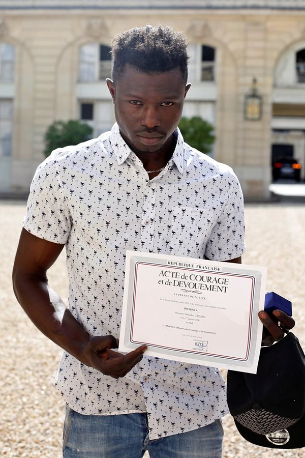 Mamoudou Gassama muestra un certificado de valentía otorgado por la Policía de París. (Foto Prensa Libre: EFE)