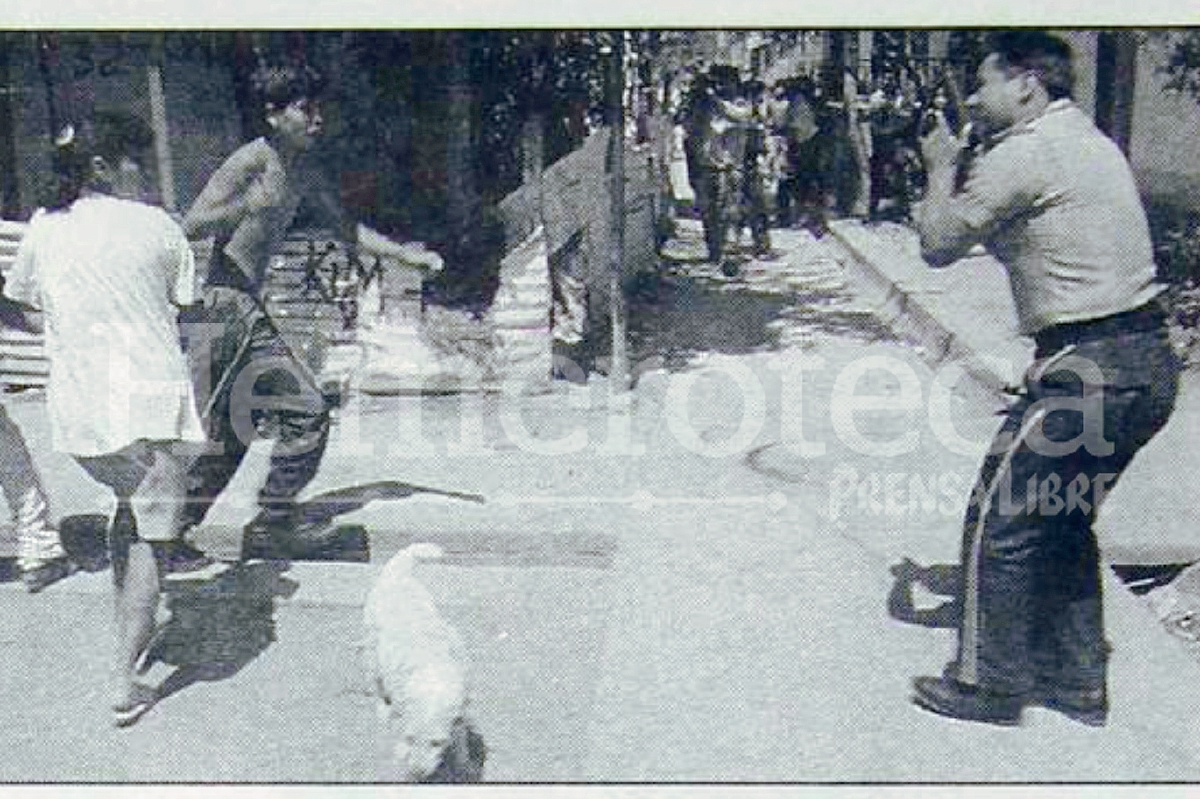 Uno de los pandilleros amenaza con una granada a las fuerzas de seguridad al salir de la vivienda. Foto: Hemeroteca PL.