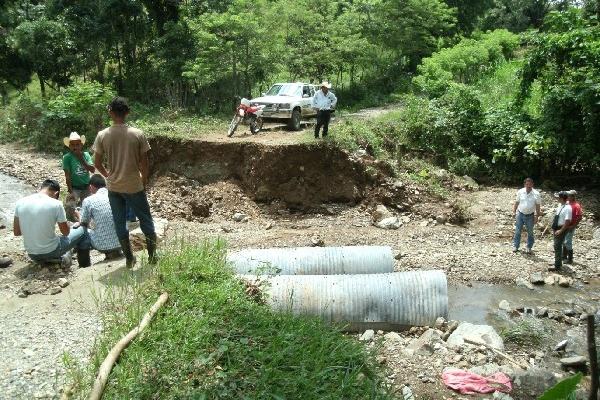 Vecinos observan los restos del puente destruido, en Los Amates.