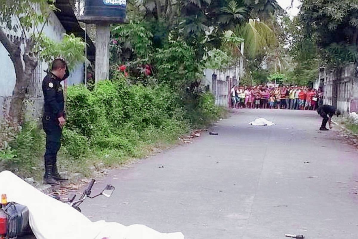 Los cadáveres  de los dos hombres  quedaron sobre  la cinta asfáltica, en el barrio El Peñate, Puerto San José, Escuintla. (Foto Prensa Libre: Carlos Enrique Paredes)