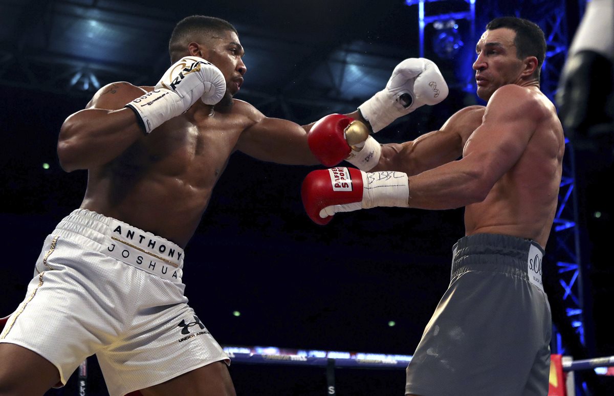 Anthony Joshua (izquierda) derrotó a Wladimir Klitschko y retuvo el cinturón de los pesos pesados. (Foto Prensa Libre: AP).