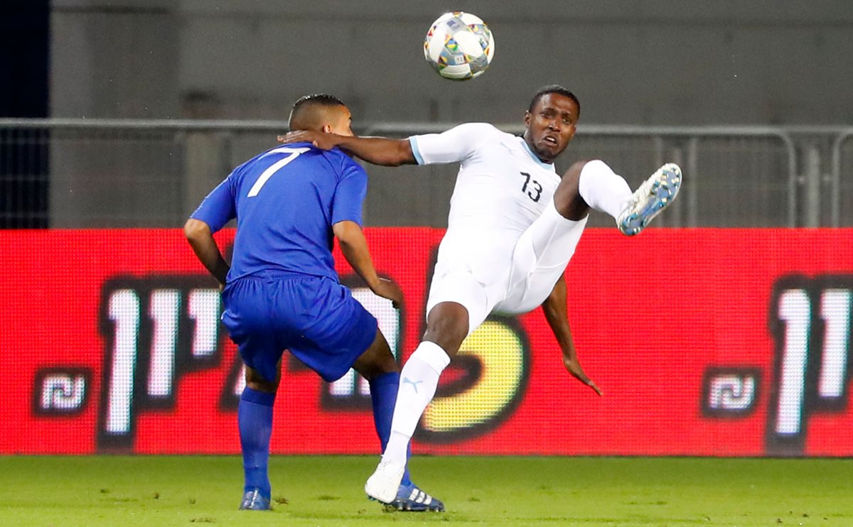 Taleb Tawatha, de Israel, pelea el balón con Marvin Ceballos, de Guatemala. (Foto Prensa Libre: AFP).