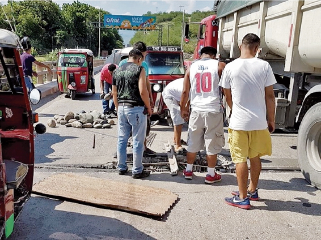 Un grupo de pilotos de El Rancho repara el puente Chetumal.