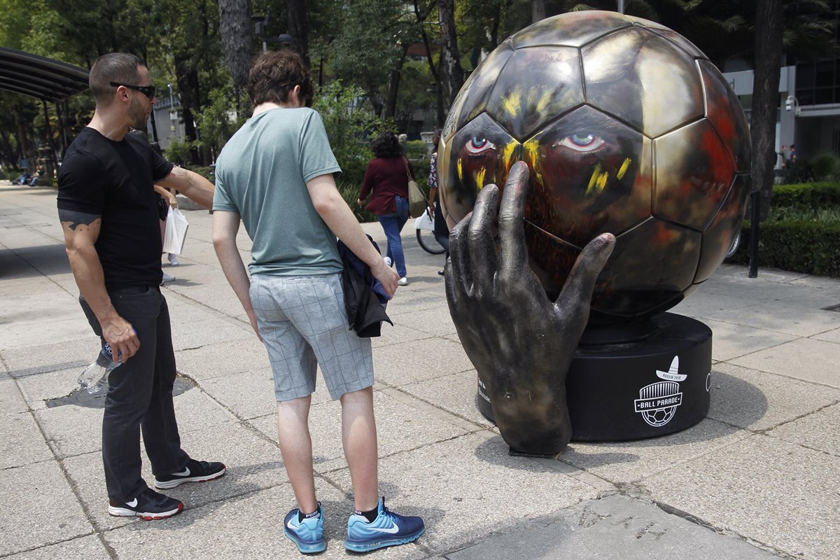 Personas observan el balón "Rode Duivels" intervenido por la artista mexicana Tere Muñoz. La afición mexicana es una de las que más interés ha demostrado por los boletos de Rusia 2018. (Foto Prensa Libre: EFE)