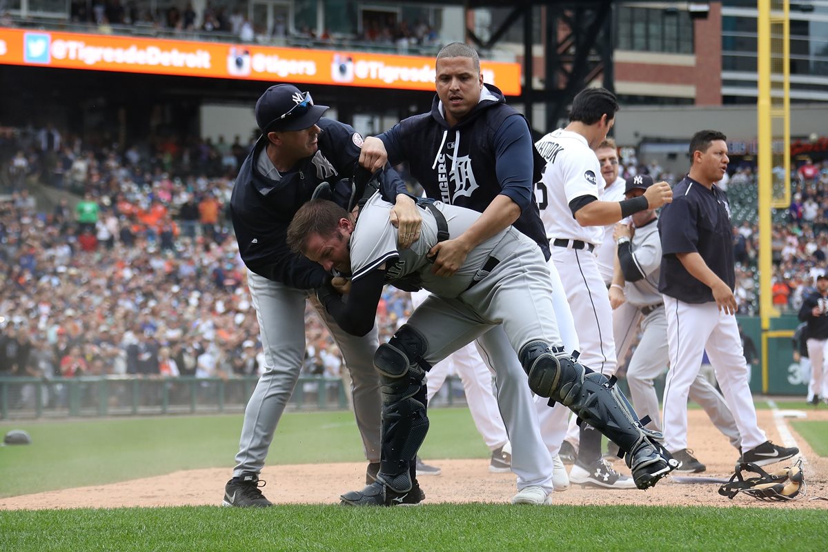 El cátcher Austin Romine es tomado por sus compañeros luego de una pelea que sostuvo con Miguel Cabrera. (Foto Prensa Libre: AFP)