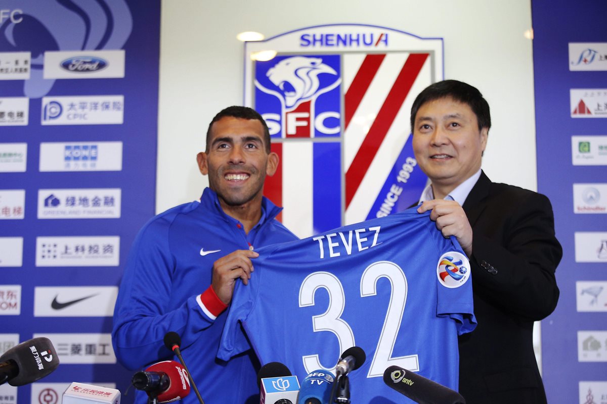 Carlos Tevez muestra su nueva camisola en su presentación. (Foto Prensa Libre: AFP)