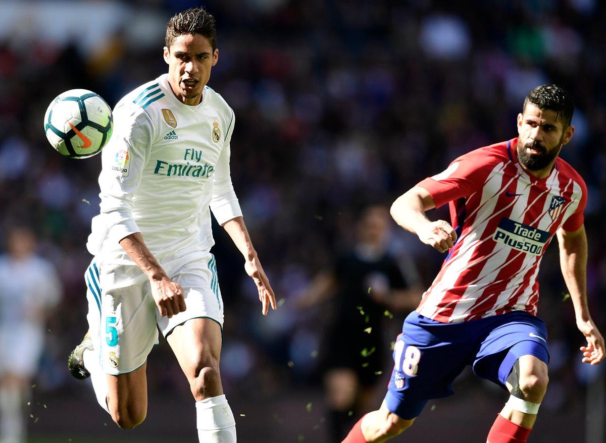 Raphael Varane corre por el balón ante la vista de Diego Costa. (Foto Prensa Libre: AFP)