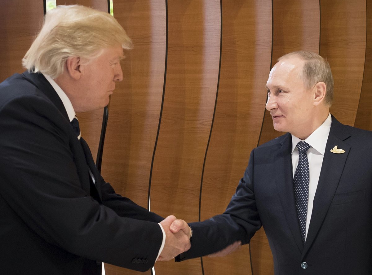 Histórico saludo de Trump -izquierda- y Putin, en Alemania. (Foto Prensa Libre: EFE)