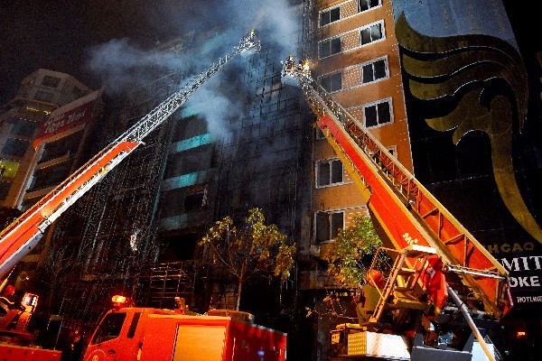 Bomberos combaten el fuego durante el incendio en un bar de karaoke de Hanoi. ((Foto Prensa Libre:EFE).