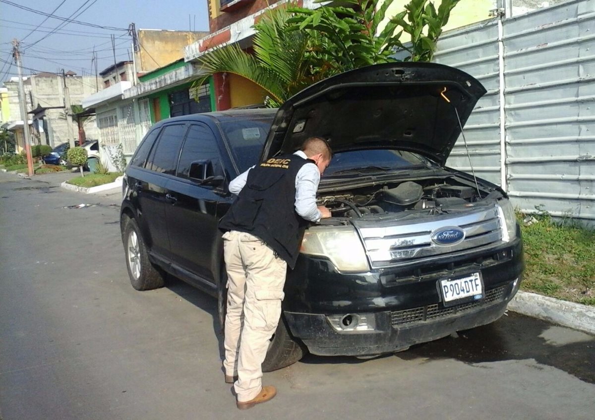 Agente de la PNC revisa uno de los vehículos recuperados. (Foto Prensa Libre: PNC)