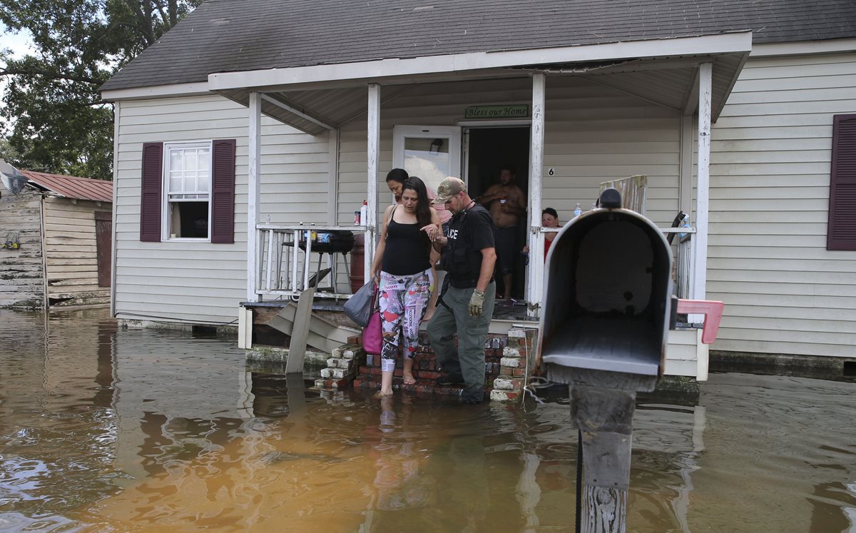 Agentes de Carolina del Norte ayudan a pobladores a evacuar sus viviendas en Lumberton. (Foto Prensa Libre: AFP)