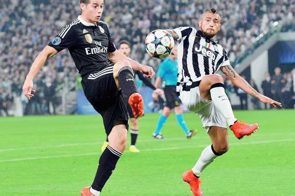 El jugador de Real Madrid, el colombiano James Rodríguez (i) disputa el balón ante el chileno Arturo Vidal (d), del Juventus. (Foto Prensa Libre: EFE)