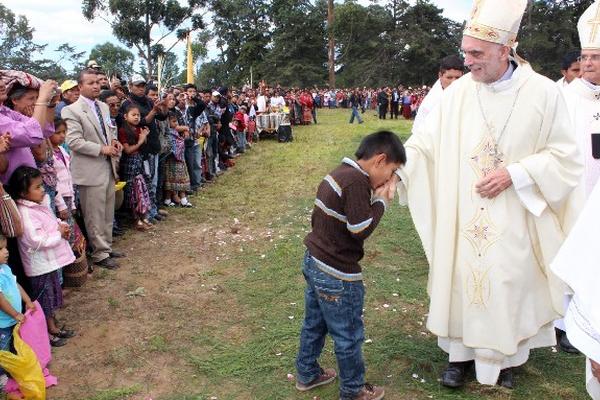 UN NIÑO besa con devoción la mano de monseñor Rosolino Bianchetti.