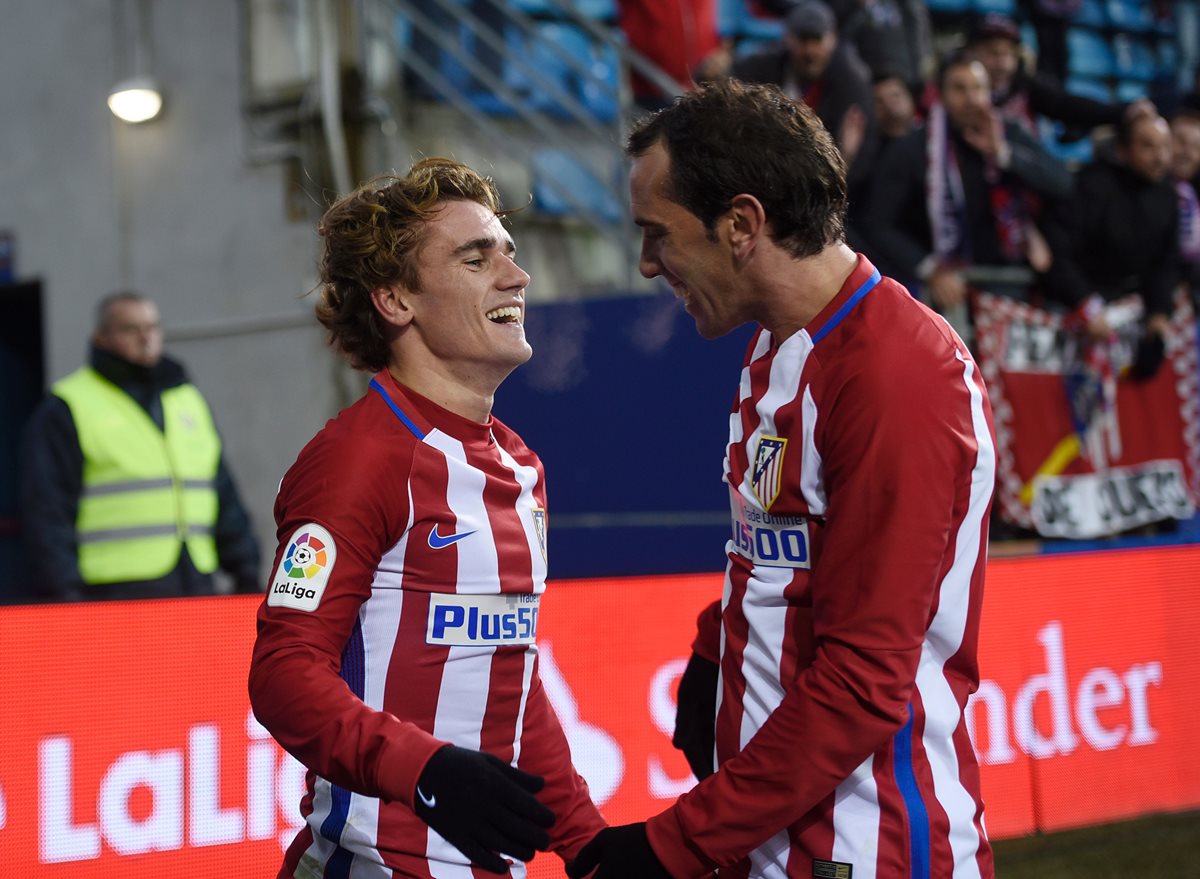 Griezmann celebra con su compañero de equipo Diego Godín luego de anotar un gol. (Foto Prensa Libre: AFP)