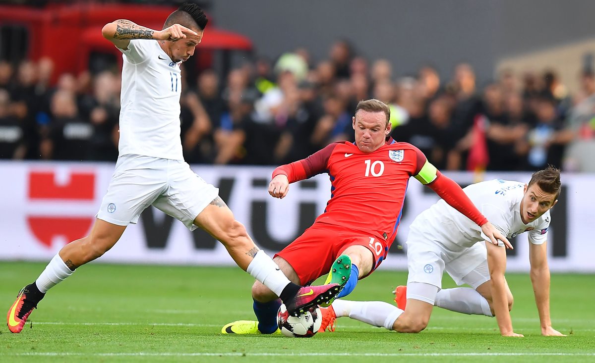 Wayne Rooney en una jugada contra Eslovaquia entre Marek Hamsik y Jan Gregus. (Foto Prensa Libre: AFP)