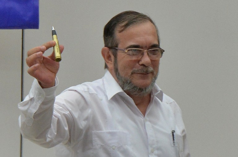 Rodrigo Londoño, alias "Timochenko", sostiene la pluma que recibió del presidente Juan Manuel Santos. (Foto Prensa Libre: AFP).