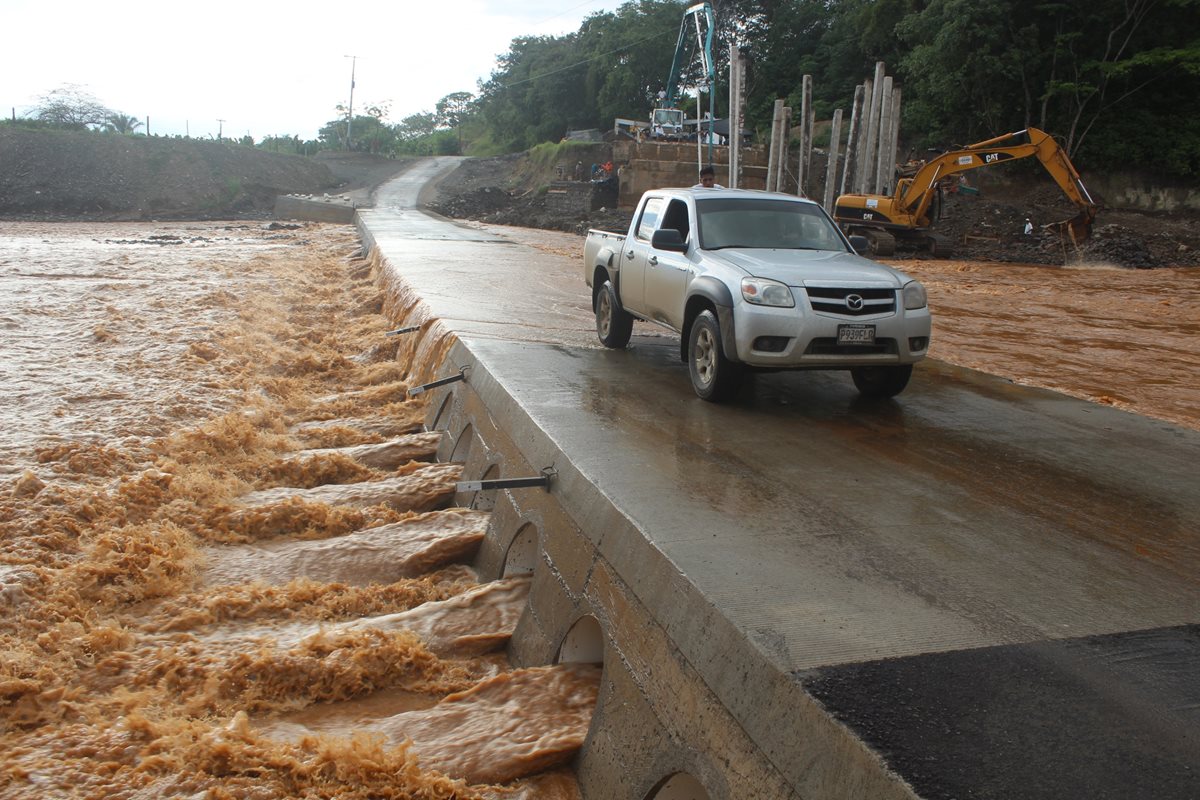 Un vehículo transita por el puente provisional construido sobre el río Túnico, en El Estor, Izabal. (Foto Prensa Libre: Edwin Perdomo)