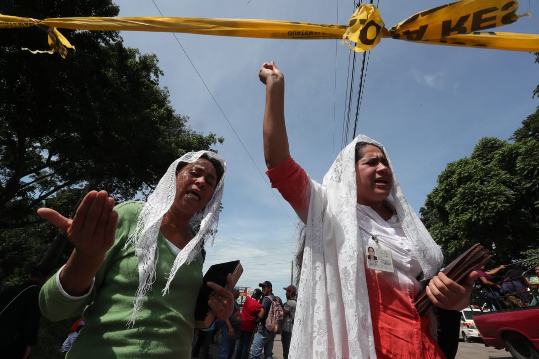 Mujeres oran en las afueras del área cero para pedir por las personas que trabajan en el lugar y por las almas de los fallecidos.