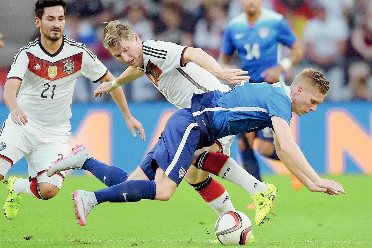 Bastian Schweinsteiger (atrás) de Alemania disputa el balón con Aron Johannsson de EE.UU. (Foto Prensa Libre: EFE)