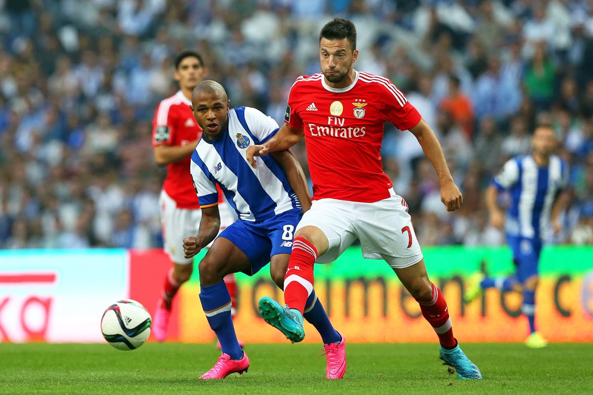 Yacine Brahimi -8- pelea el balón con Andreas Samaris -7- del Benfica durante el clásico portugués. (Foto Prensa Libre: EFE)