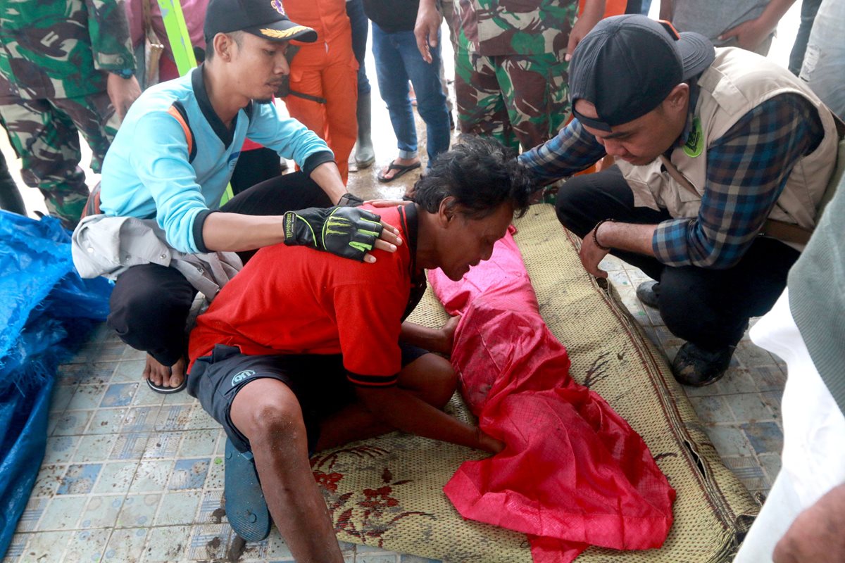 Este hombre observa el cadáver de su hijo en el sur de Lampung, Sumatra, Indonesia, después del tsunami.