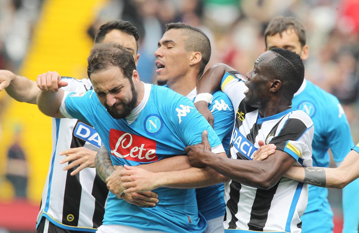 Jugadores del Napoli y del Udinese intentan detener al argentino Gonzalo Higuaín después de ser expulsado. (Foto Prensa Libre: EFE)