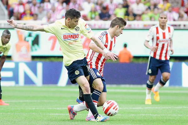 El jugador de Chivas del Guadalajara Carlos Fierro (i) disputa el balón con Pablo Aguilar (d) de América. (Foto Prensa Libra: EFE)