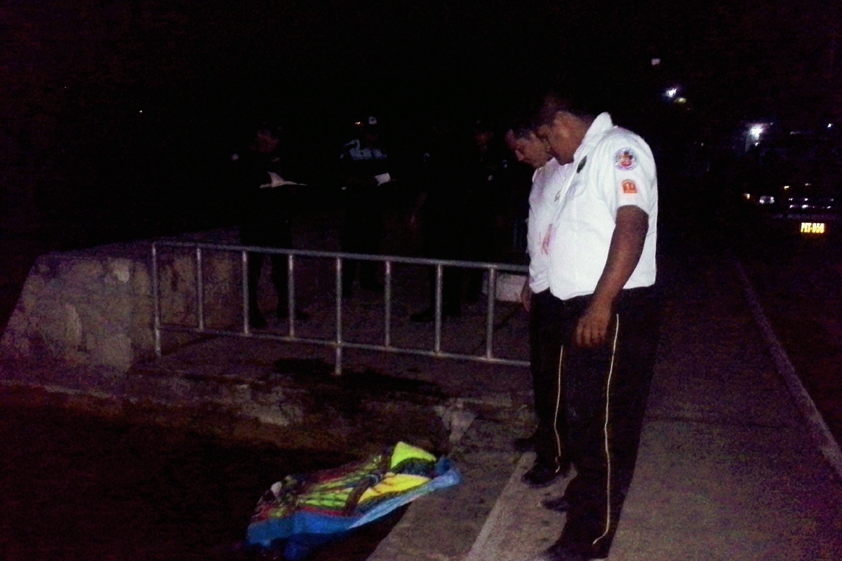 Socorristas observan el cadáver de Luis Fernando Jiménez López, en Flores, Petén. (Foto Prensa Libre: Rigoberto Escobar)